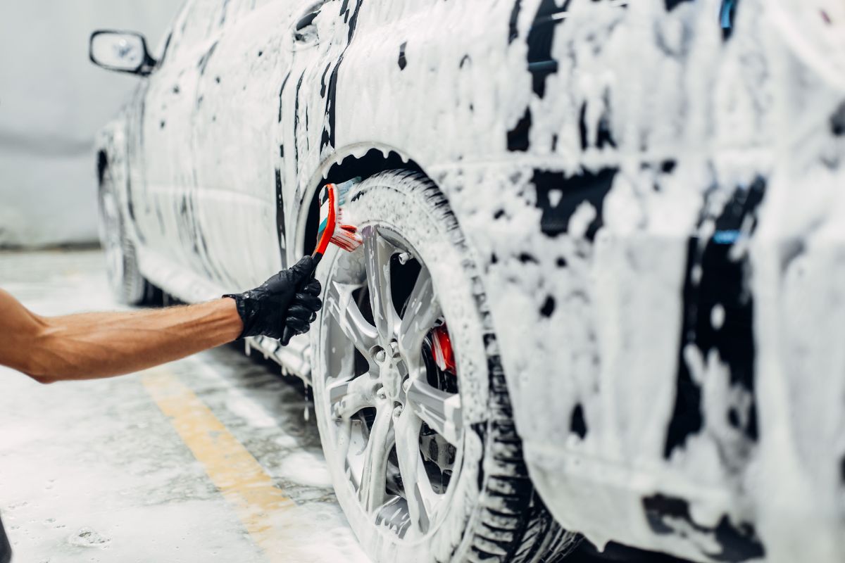 The image of a man's hand cleaning the car with soap which refers to overpriced car washes is overpriced for the work done, purchasing your own cleaning supplies can save money in the long run. 