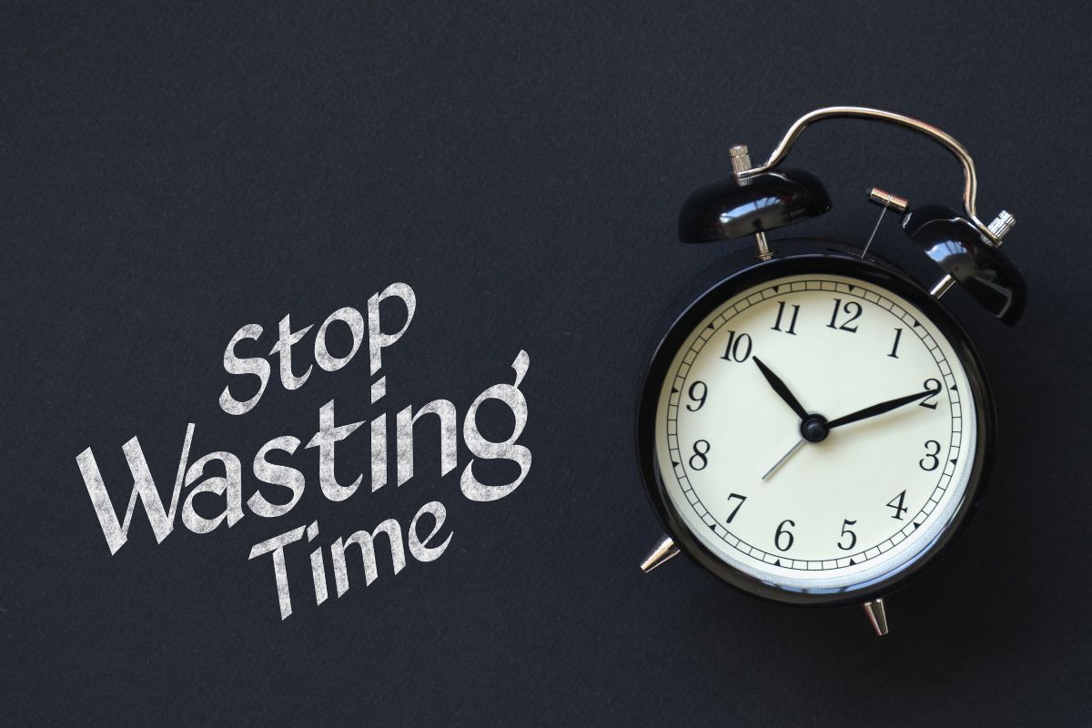 The picture shows a board with notes and a clock referring to wasting time can cost more than money, setting goals and sticking to a routine can make a huge difference.