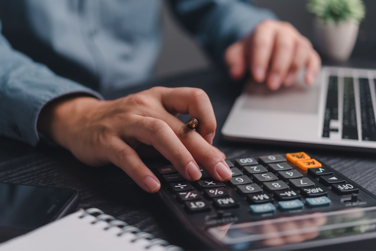 The image shows a man's hand budgeting.