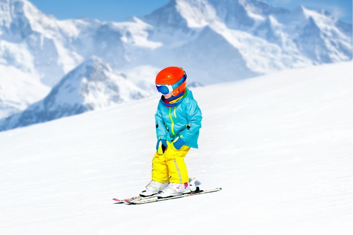 The photo of a kid wearing his winter clothes while skiing at the snow field refers to a kid's travel sports that can be a huge financial drain, switching to recreational leagues can be more affordable.