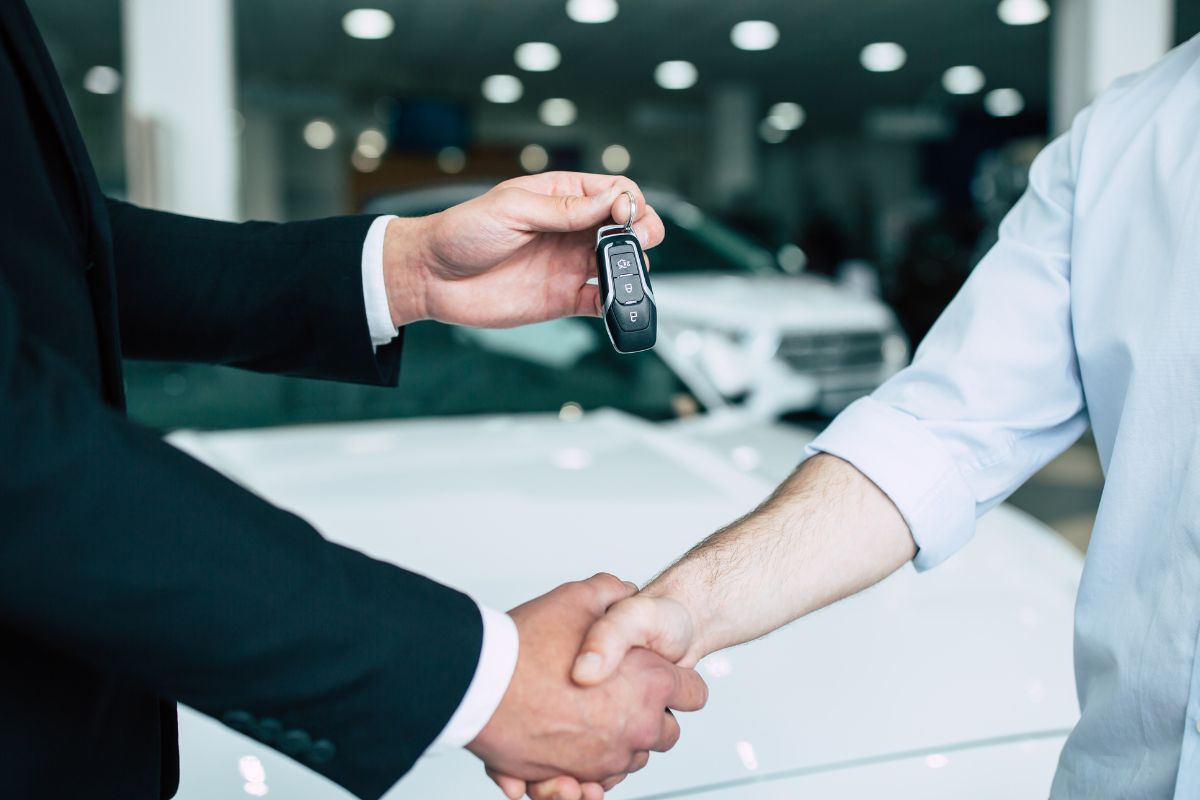 The photo shows a man with a newly purchased car.