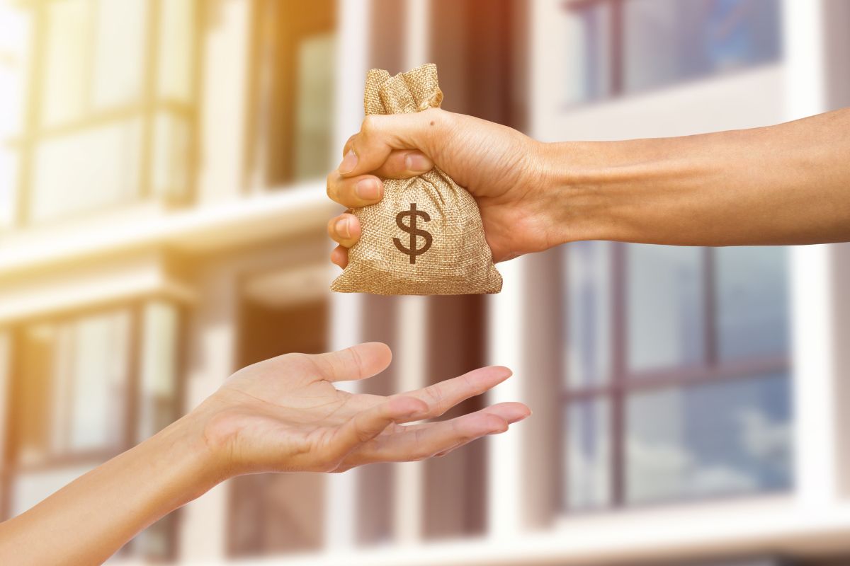 The photo shows a man's hand handing a bag of money to the girl's hand which means lending money to friends or family without clear agreements often leads to financial trouble, a written plan helps avoid misunderstanding.