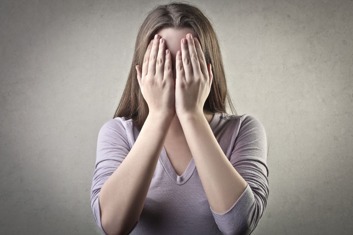 The photo tells about a girl covering her face which refers to letting fear of failure can hold back financial success, avoiding fear-driven decisions allows money to grow. 