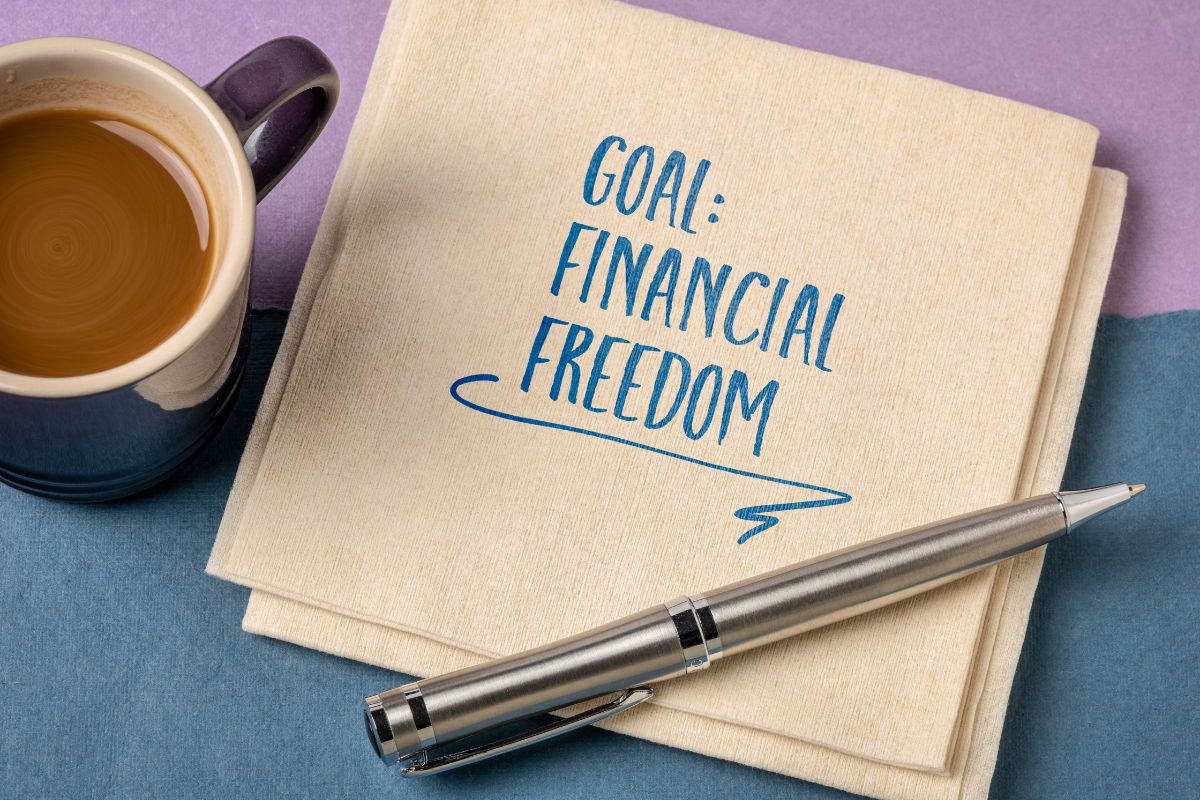 The photo shows a coffee, a pen, and tissues with notes which refers to financial freedom earned through knowledge and effort.