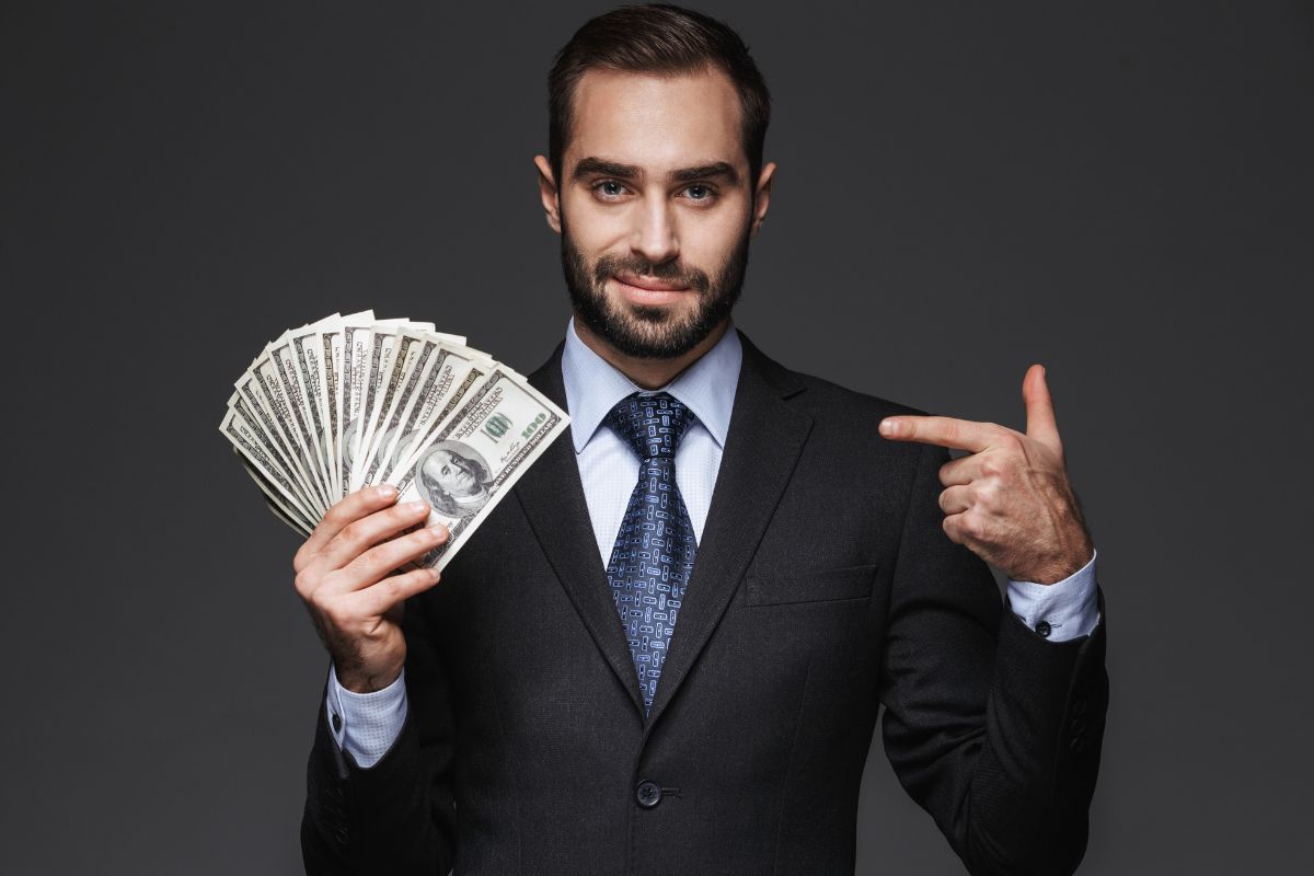 The picture is about a man holding dollar bills.