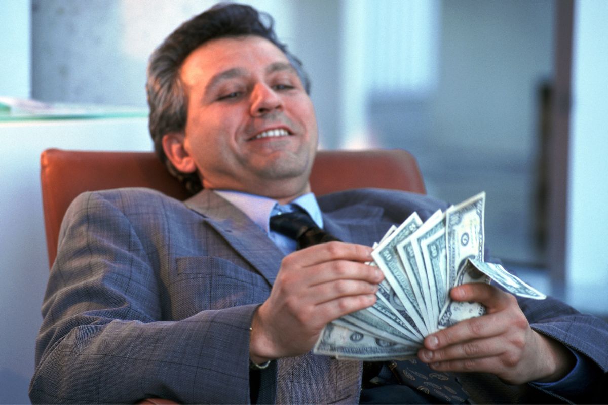 The image shows a man counting money.