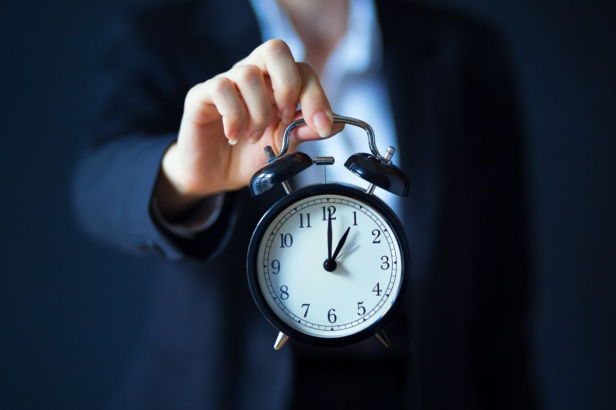 The photo tells about a girl's hand holding a clock which means making sure to use that time wisely can help you reach your money goals faster.