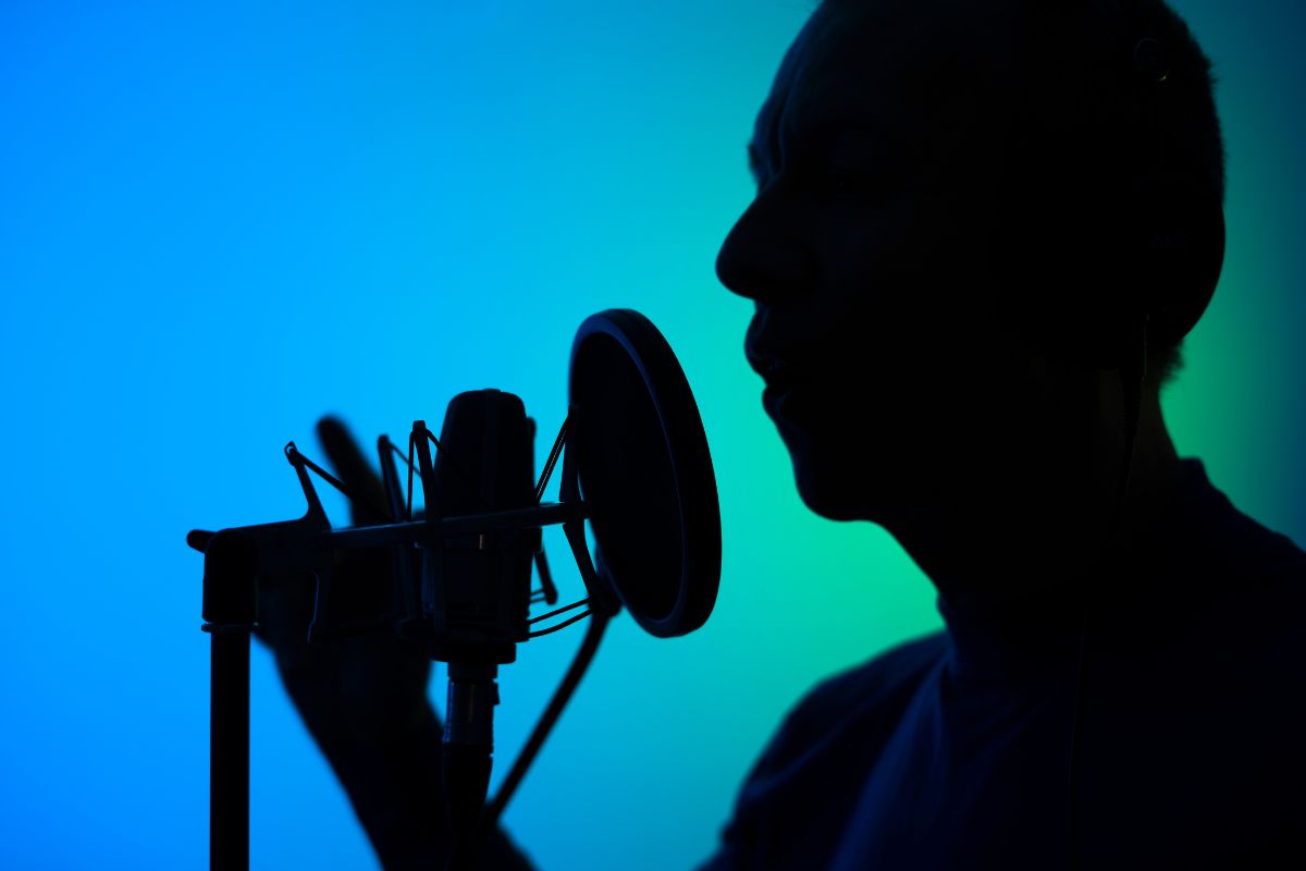 The image of a man recording his voice using a microphone means a voice-over artist can make a full income that can be a fun and profitable career.