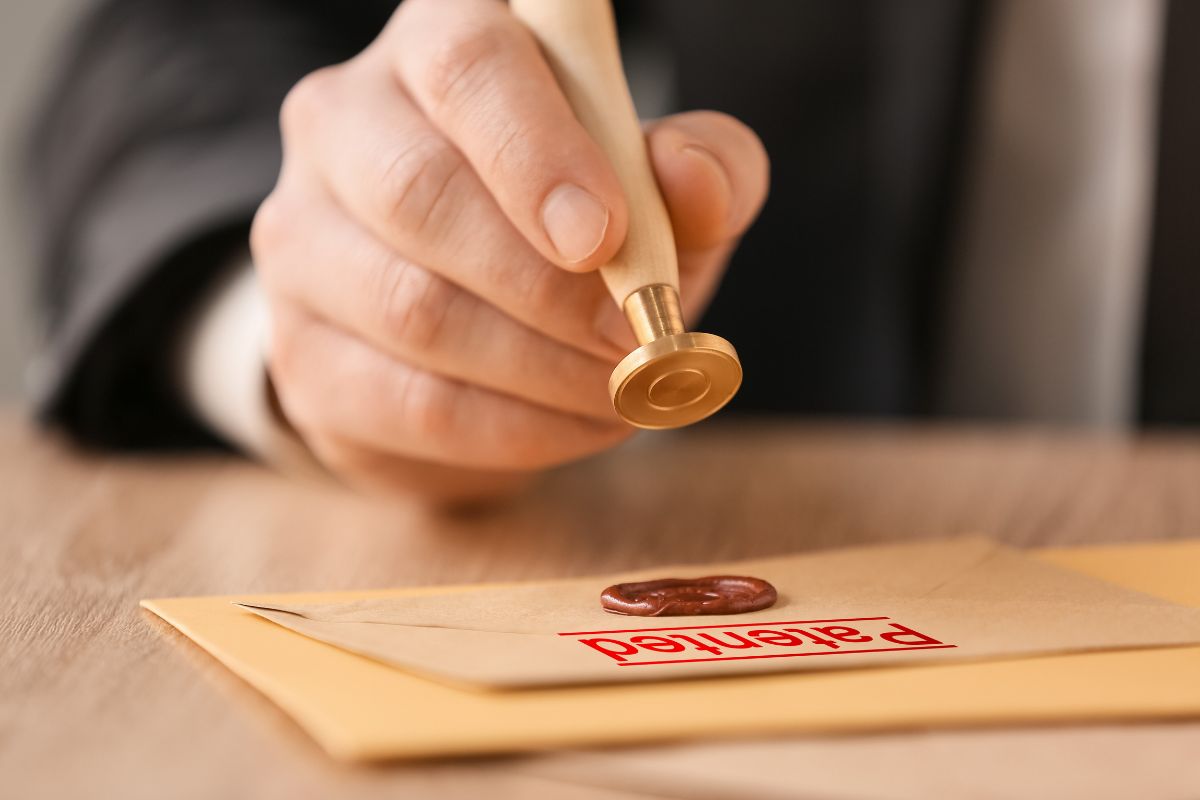 The picture shows envelopes with a label and a man's hand holding a stamp which refers to patent attorneys helping investors protect their ideas and one of the high-income careers.
