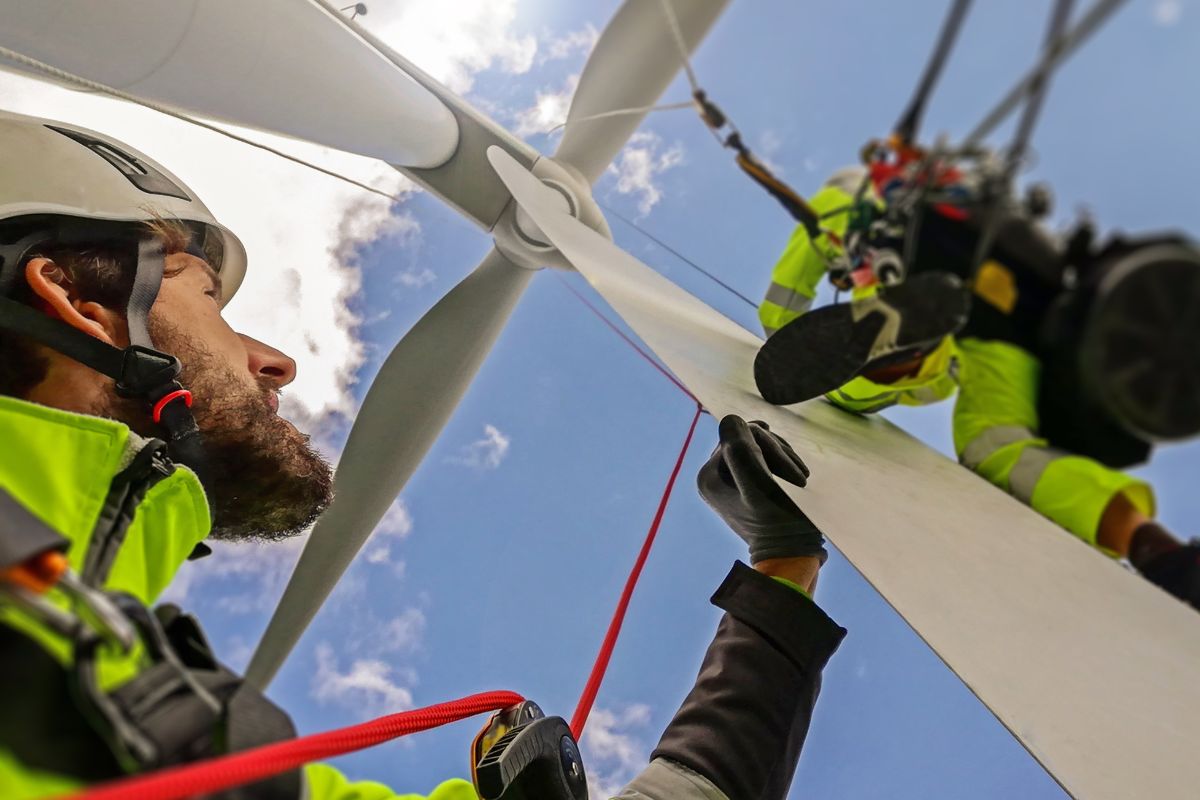 The image shows wind turbine technicians.