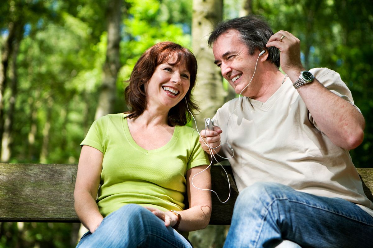 The image shows a couple listening to music while enjoying which refers to early retirement can be a great option for those wanting more time to enjoy life.