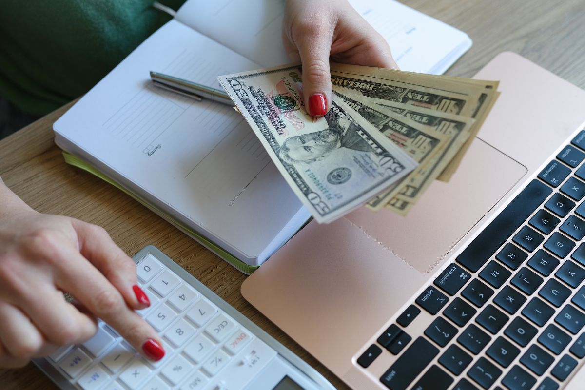 The picture shows a woman's hand doing a bare-bones budget.