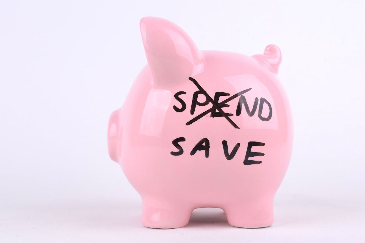 The photo shows a piggy bank with notes which refers to a no-spend challenge that helps save a lot in a short time by stopping impulse buys.