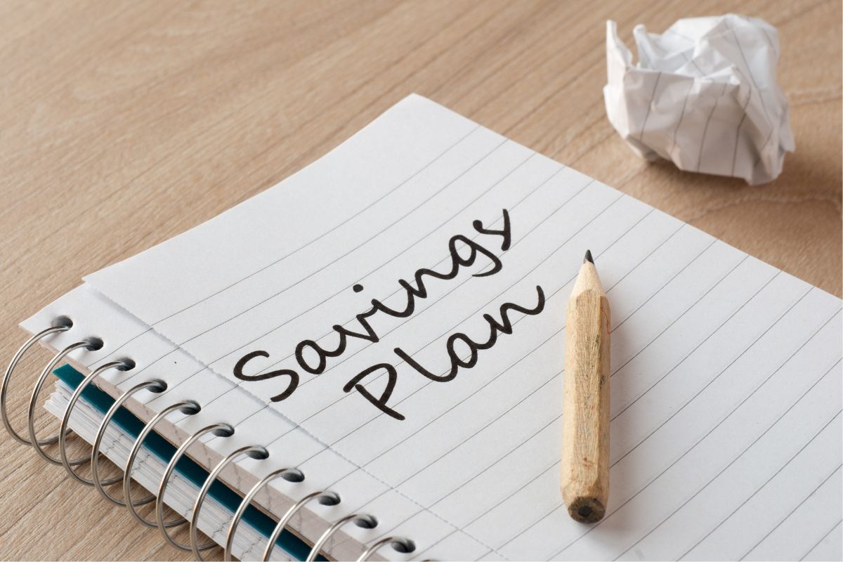 The photo tells about a crumple of paper, a pen, and a notebook with notes which means an automated savings plan is great for those who forgot to save or struggle with discipline.