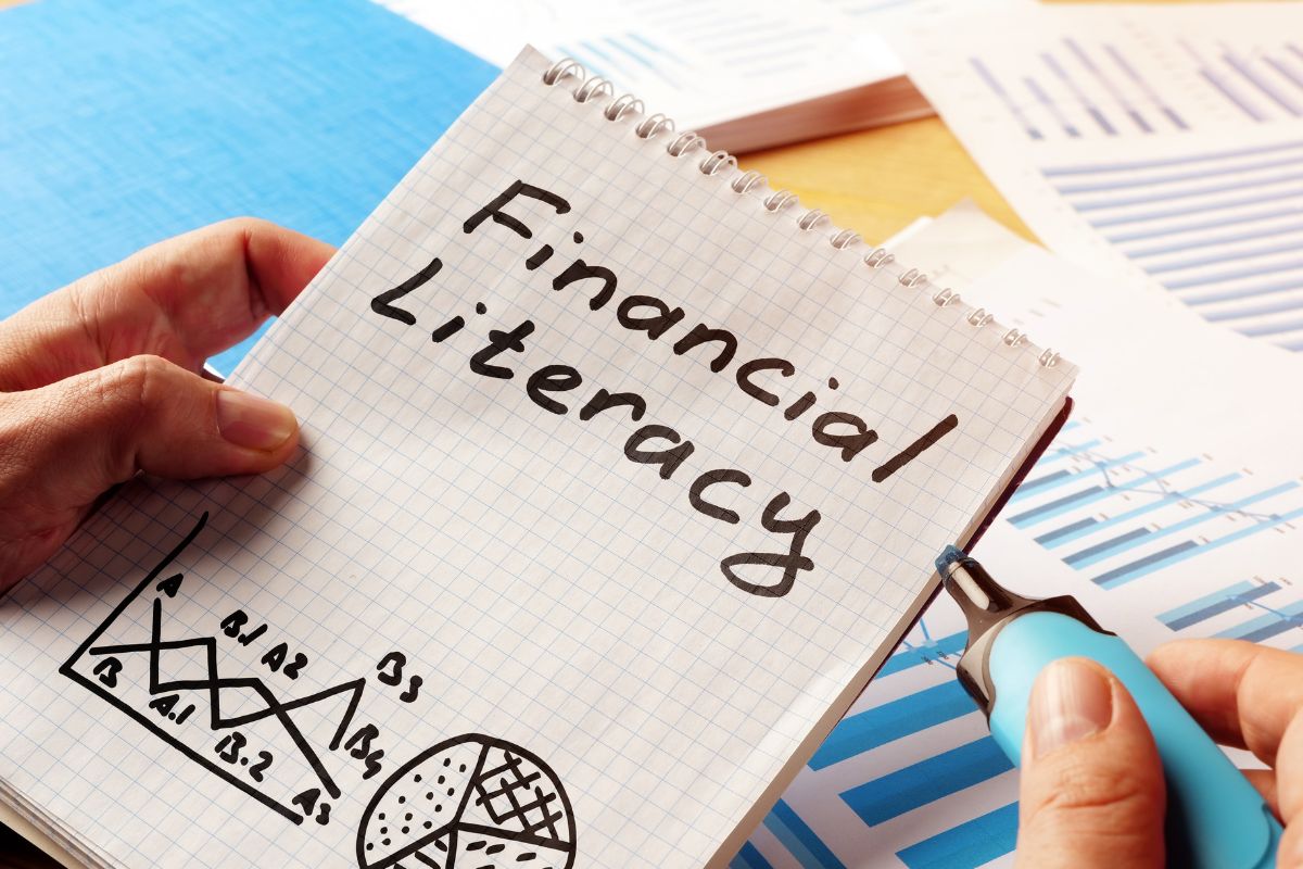 The image shows a notebook with financial literacy wording.