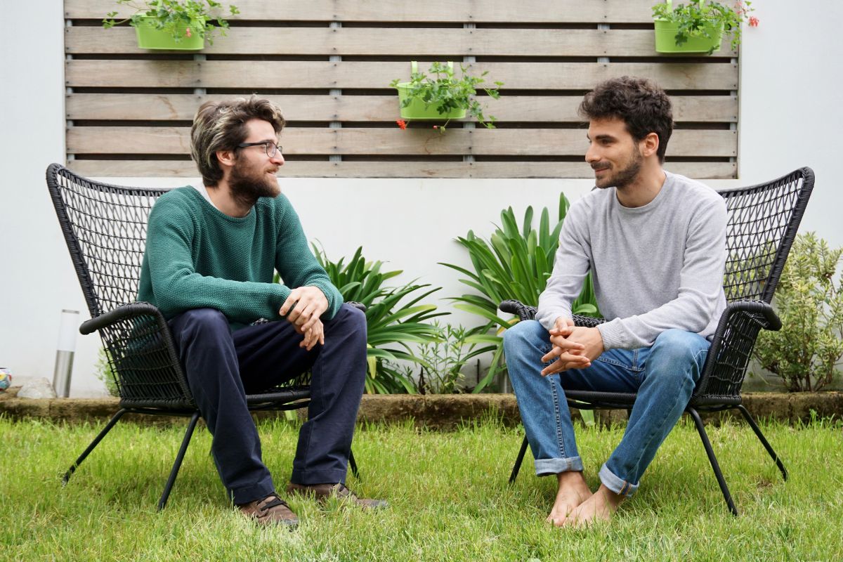 The photo shows two men talking to each other in the garden referring to effective communication helping negotiations, leadership, and even personal relationships.
