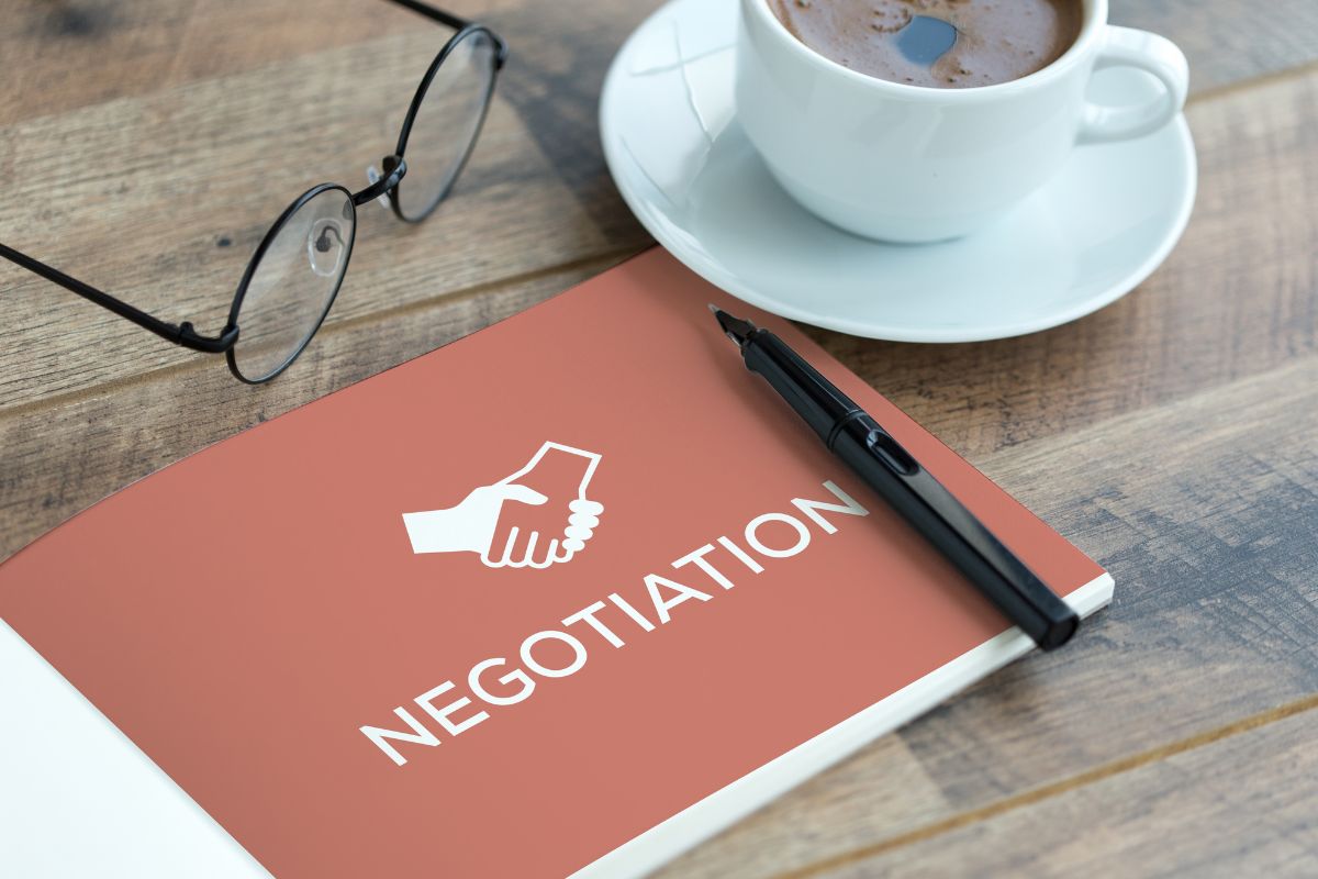 The image tells about an eyeglass, a pen, a coffee, and a book with a note which refers to learning negotiation skills helping with job offers, promotions, and handling workplace conflicts.