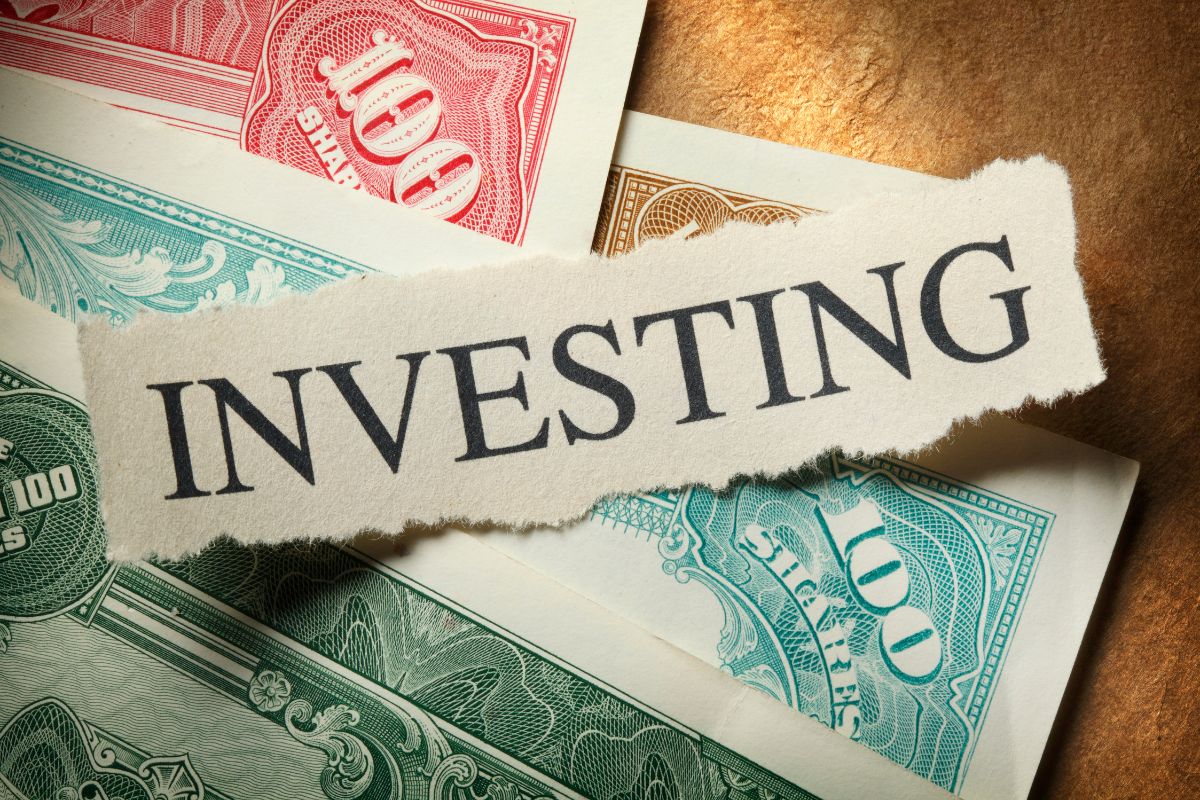 The photo shows dollar bills and a piece of paper with a note that refers to investing and wealth building early and prevents financial struggles later in life.