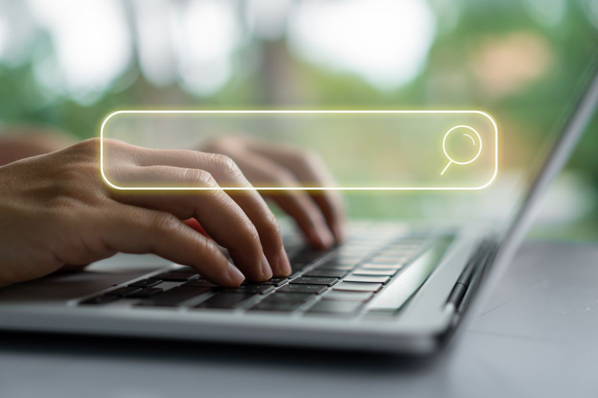 The image shows a girl's hand using a laptop and a visual search icon on the screen indicating to focus on these high-income skills early that bring real value in the workplace and make you stand out in the future.

