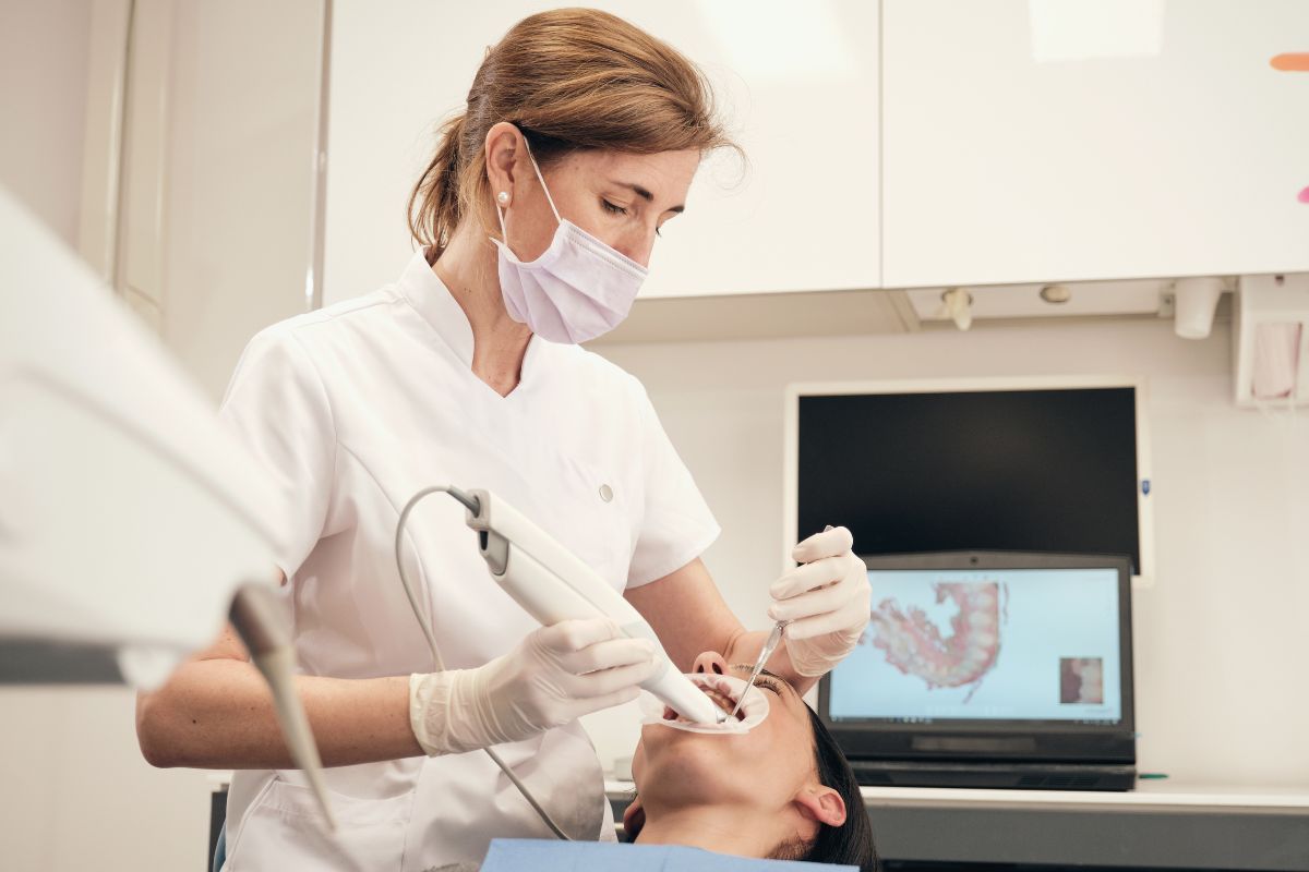The picture shows a woman working as an orthodontist.