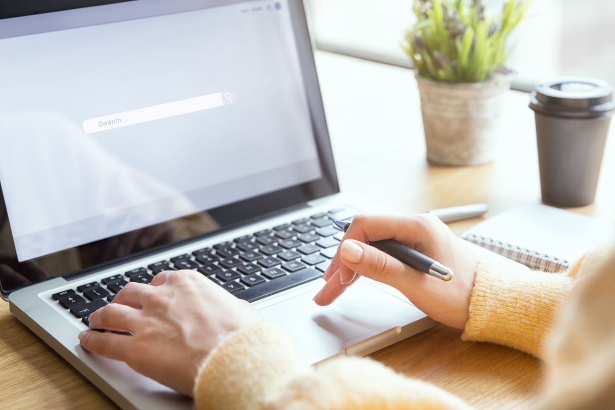 The picture is of a woman's hand using a laptop.