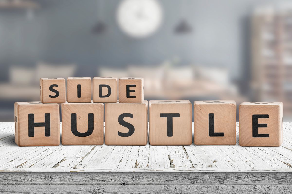 The picture shows wooden cubes with letters at the table which refers to starting that summer side hustle you dreamed of can lead to extra income and maybe even a long-term opportunity.