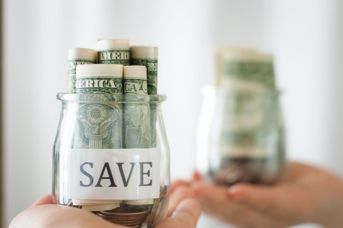 The picture shows a woman's hand holding savings.