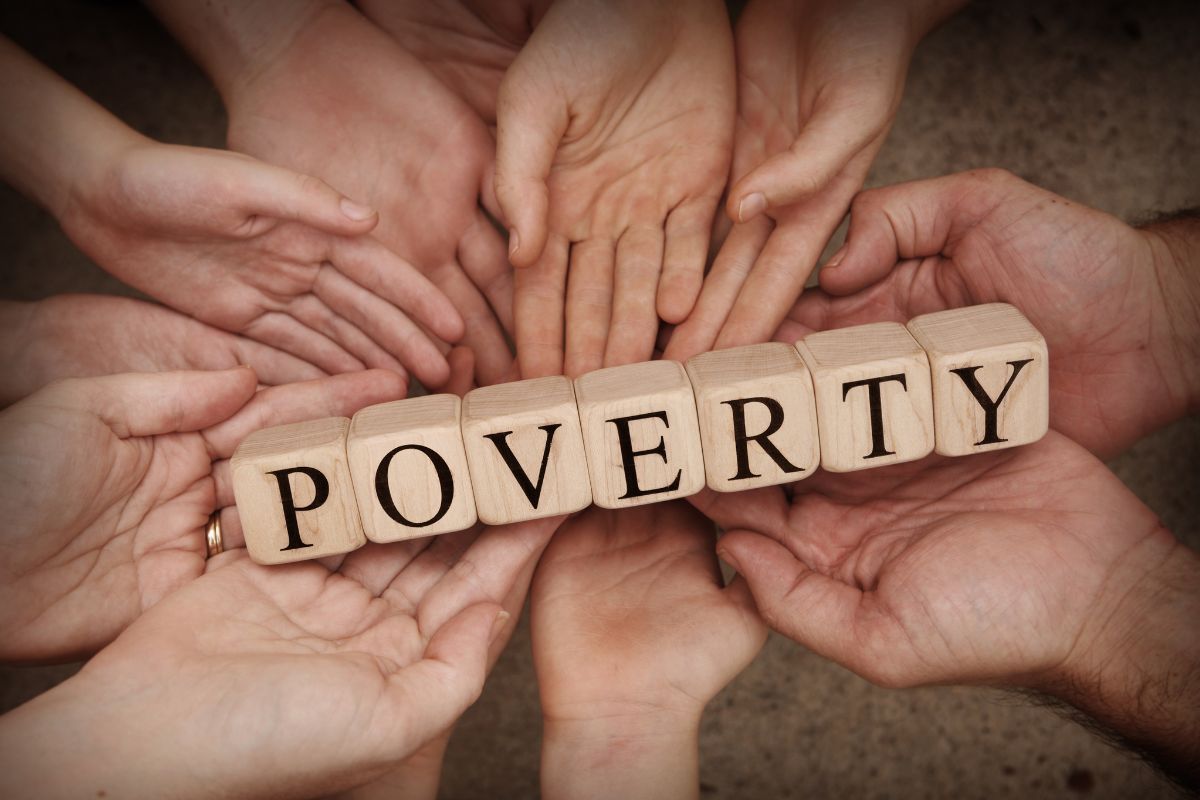 The photo shows hands with poverty wording.