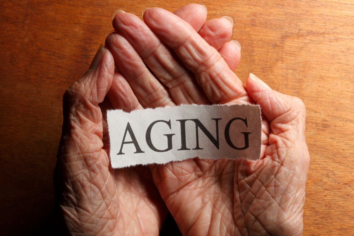 The photo shows a senior's hand holding paper with aging wording.