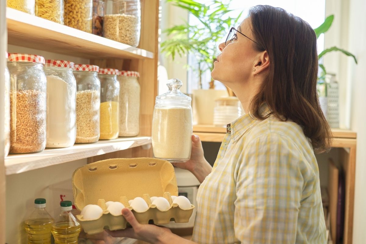 Picture of a woman checking ingredients in the pantry. 