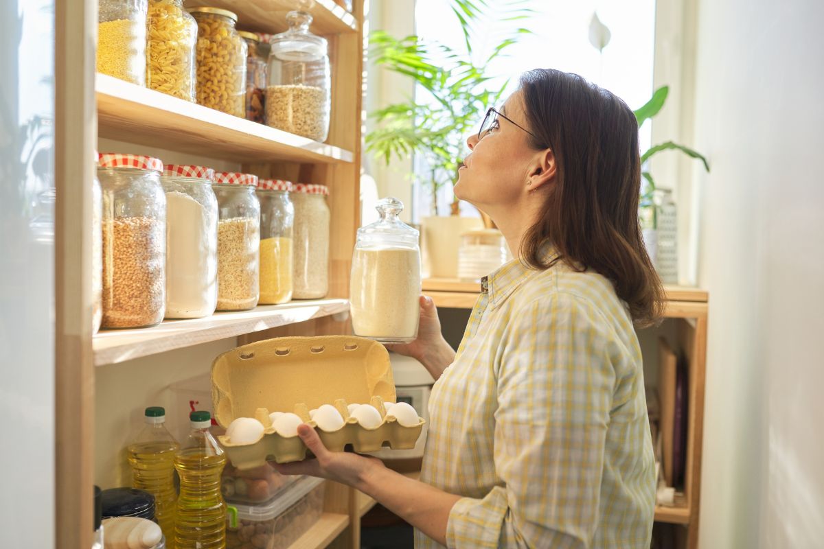 The photo tells about ingredients in jars and a girl picking up a tray of eggs and sugar indicating that using the pantry challenge prevents food waste and stretches the grocery budget.