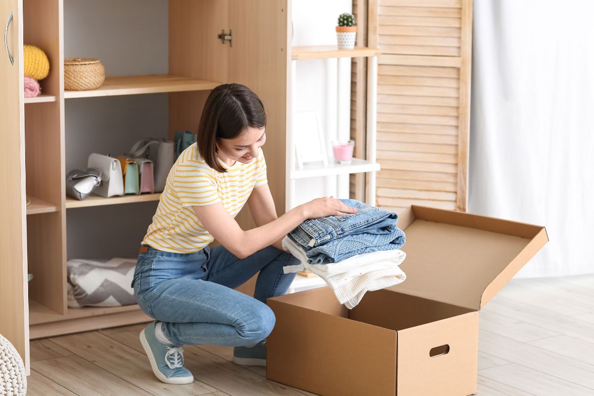 The photo tells about a cabinet with bags and other stuff, and a girl putting the clothes in a box which means turning decluttering into cash and adding cash to the budget.