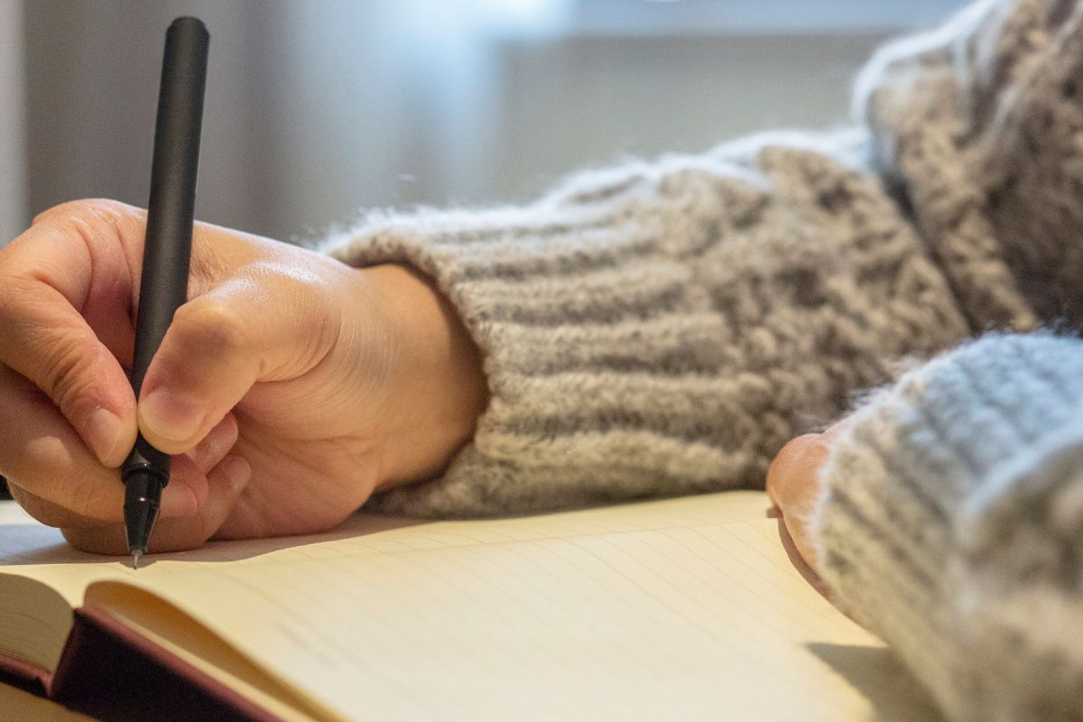 Image of someone handwriting in a notebook.