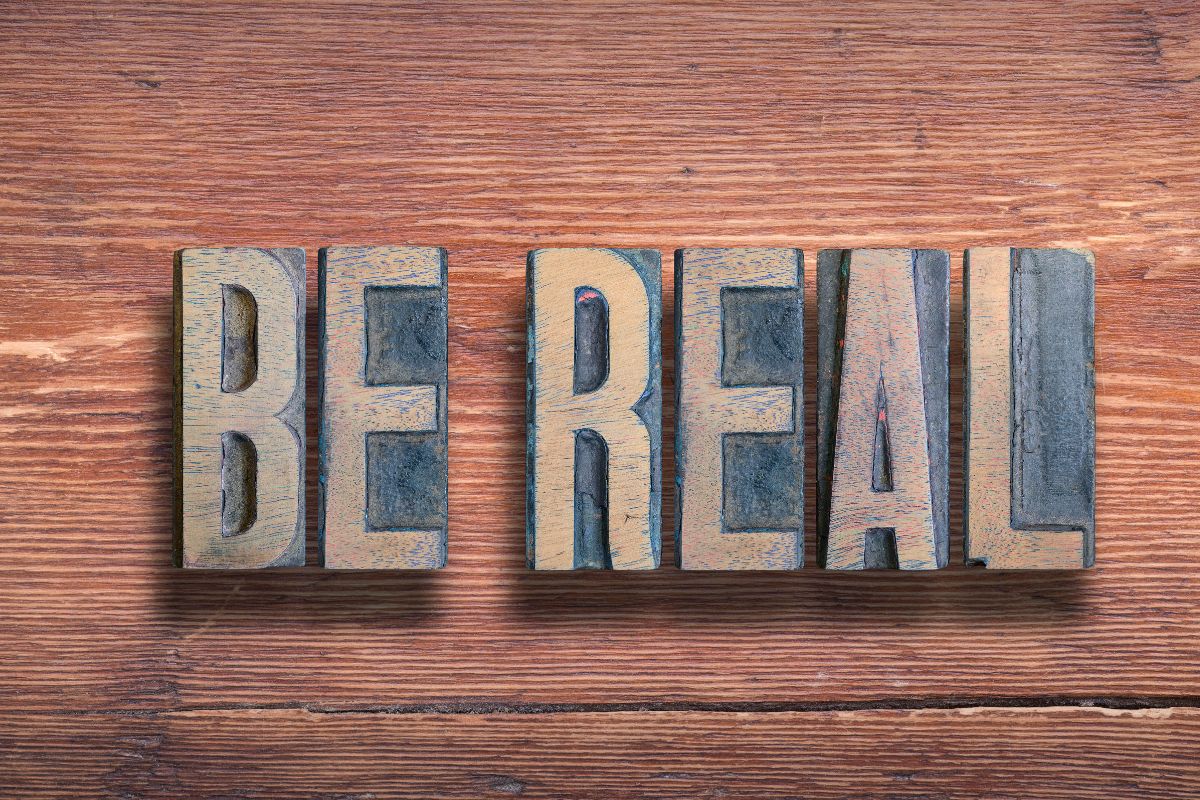 The photo shows wooden letters at the wooden table referring to let's be a real part of life that needs real planning for a piece of mind and fewer financial worries down the road.