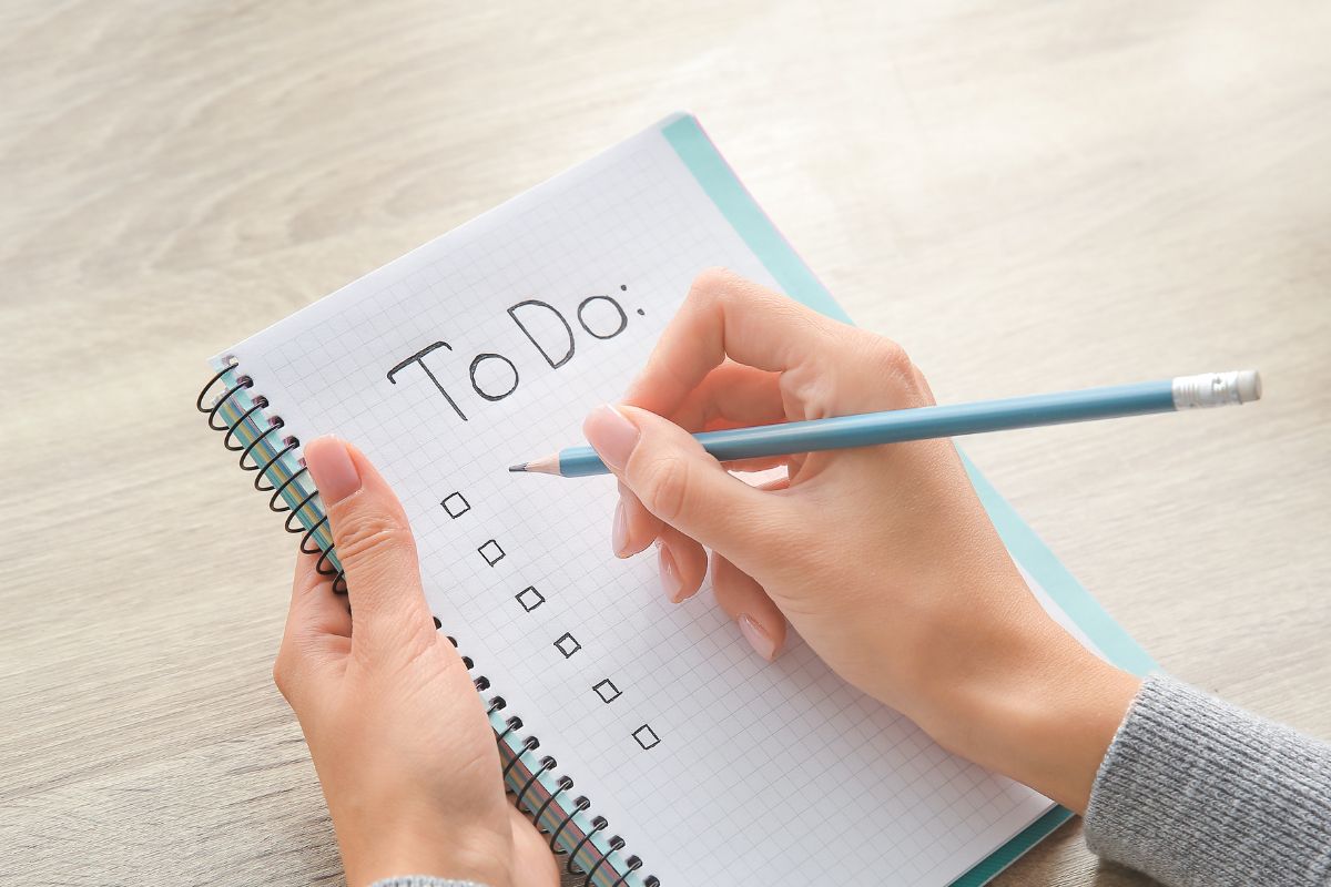 Picture of a woman's hand listing to do things. 