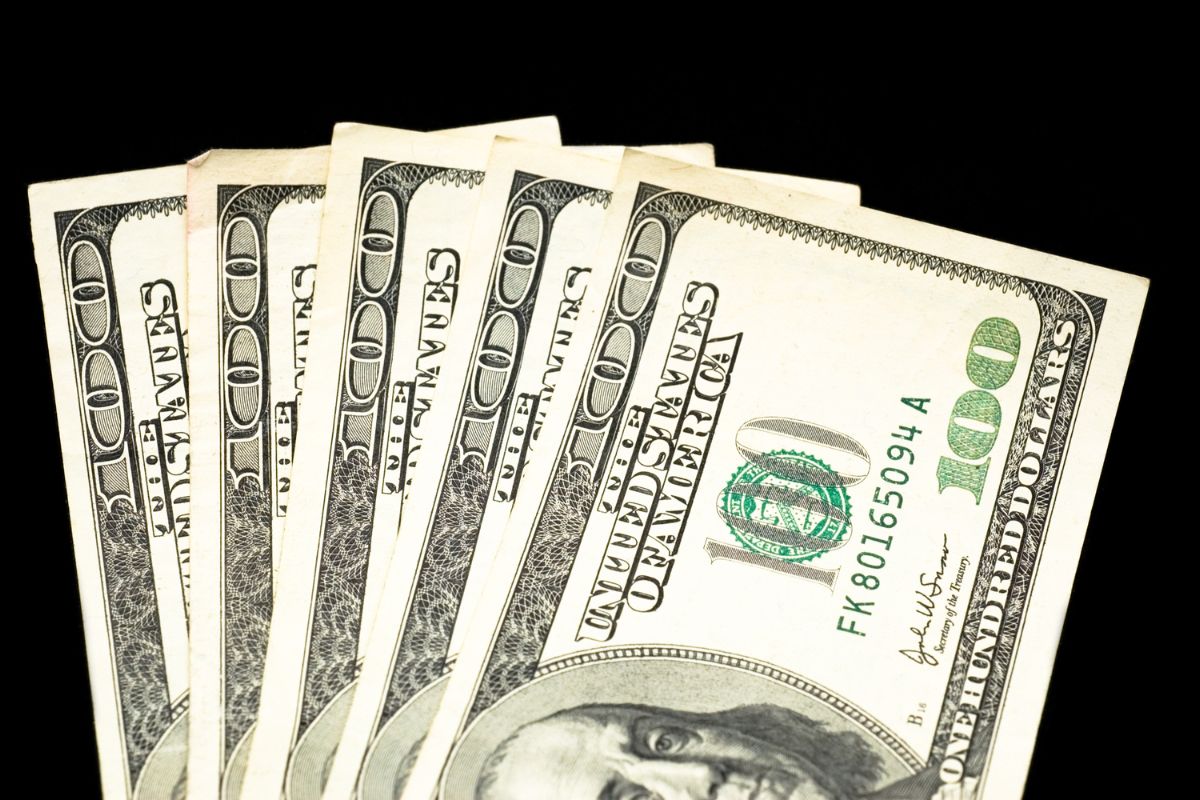 The image shows dollar bills referring to starting with saving $500 as the first step toward long-term financial stability.