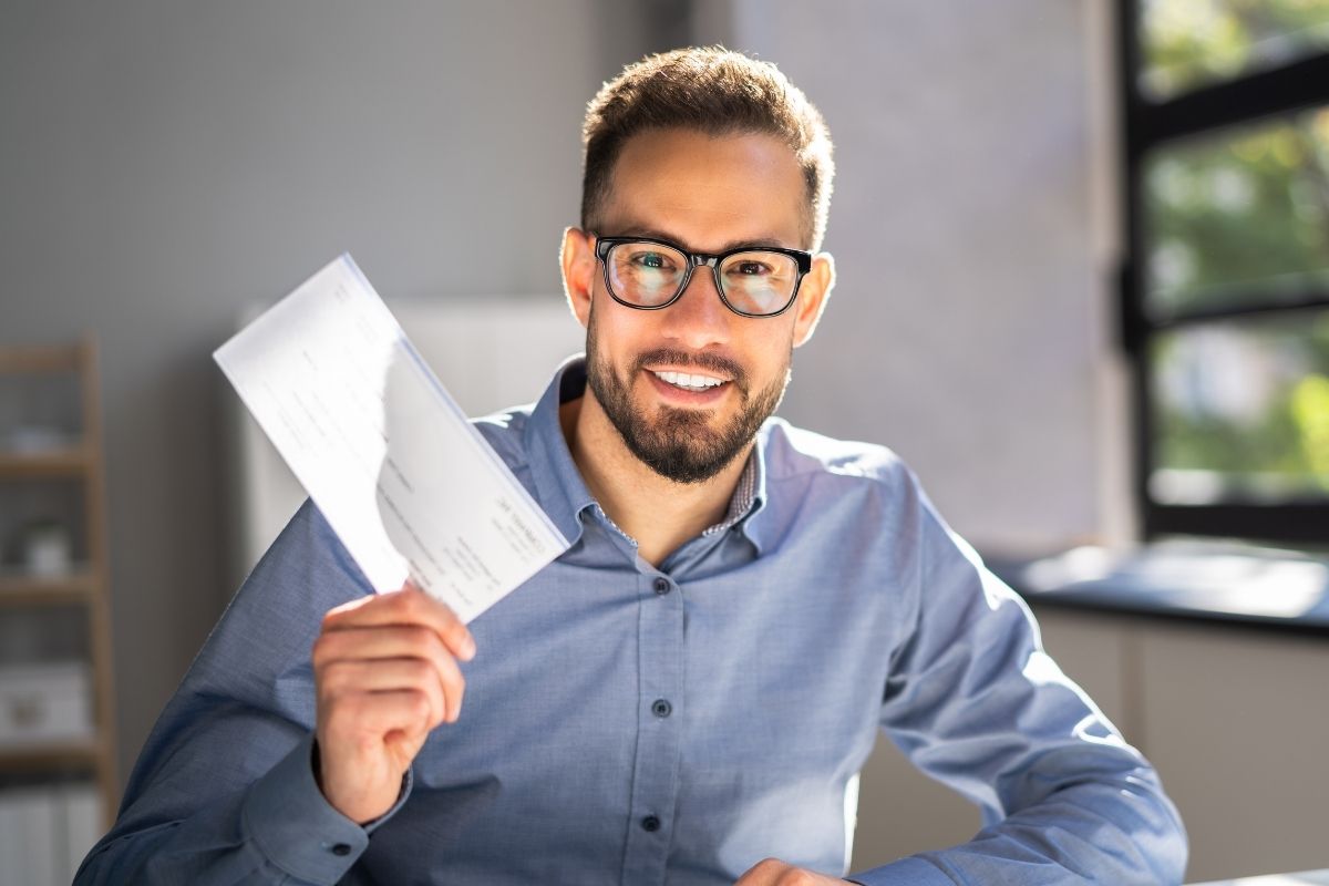 A imagem mostra um homem segurando um salário.