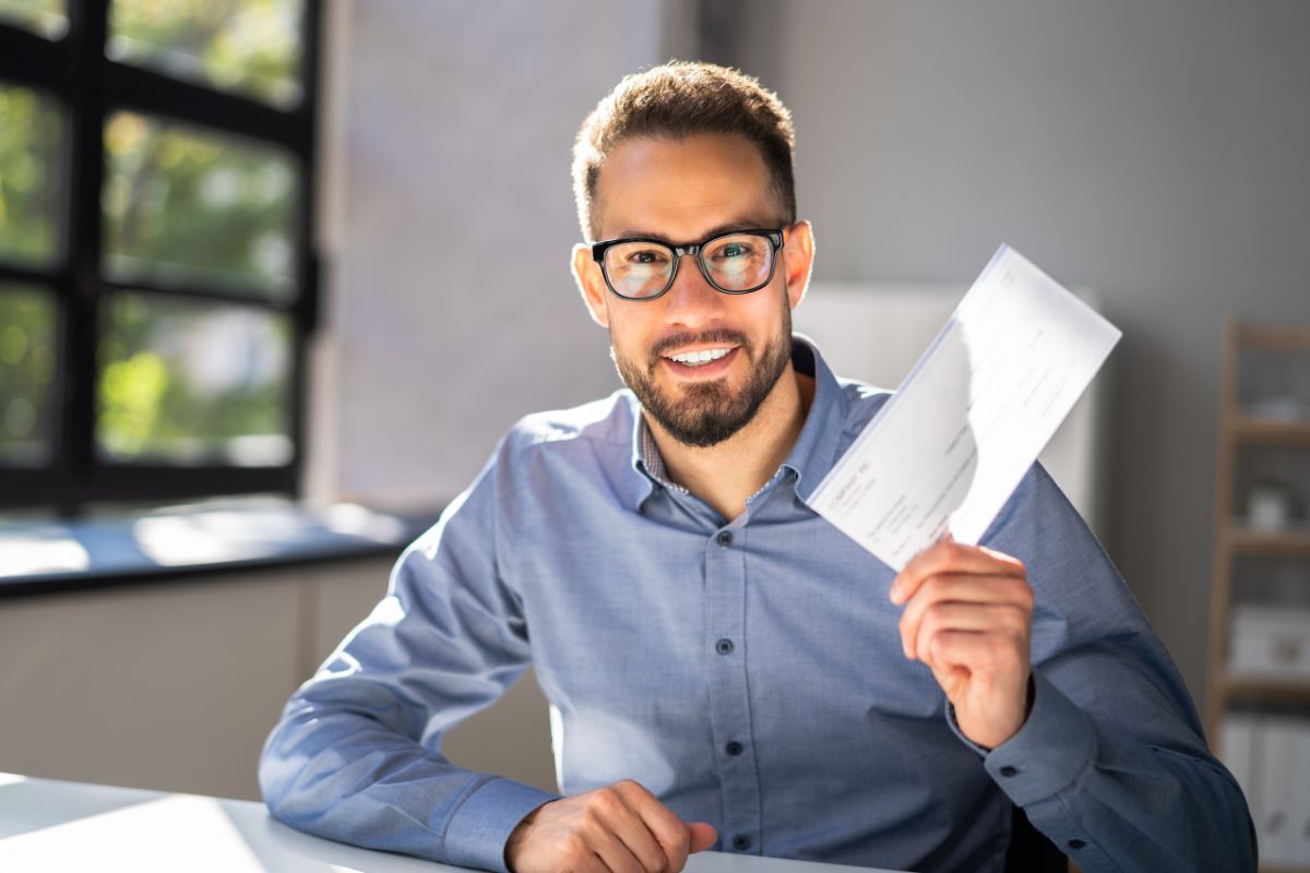 The photo tells about a man holding a piece of paper which means paying yourself first on each paycheck ensures there's always money set aside for future needs.