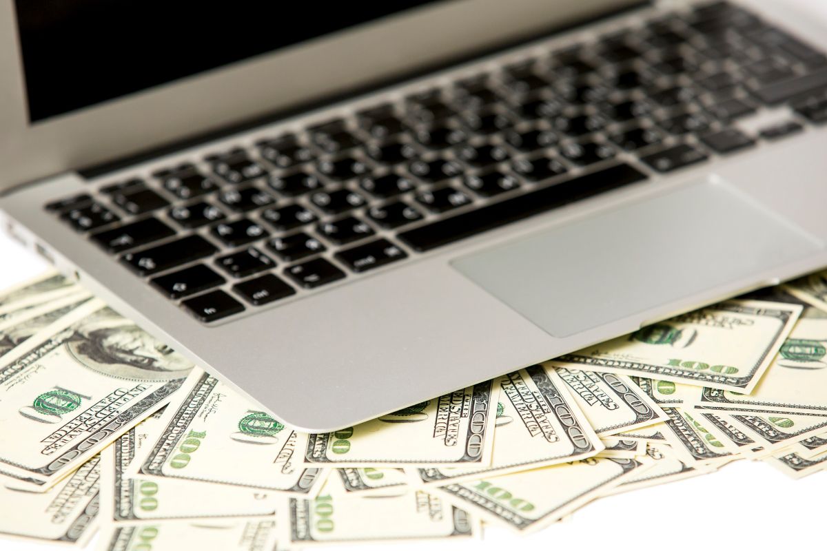 The image tells about a laptop and dollar bills referring to start with these high-income skills can bring in thousands per month.