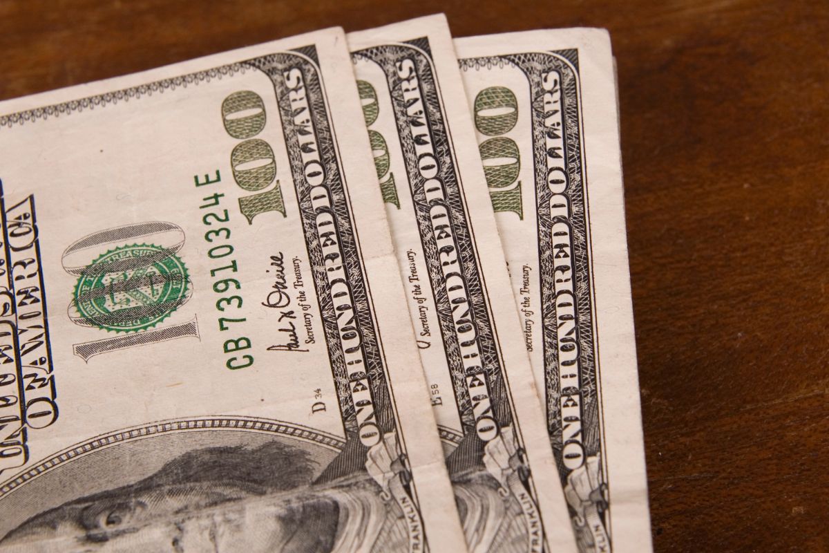 The picture tells about dollar bills on the wooden table which means starting with making $300 and hustling to see the potential for making even more.