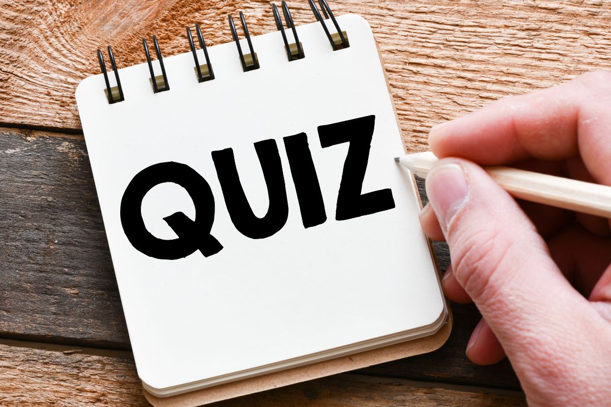 The photo shows a man's hand and a notebook with quiz wording.