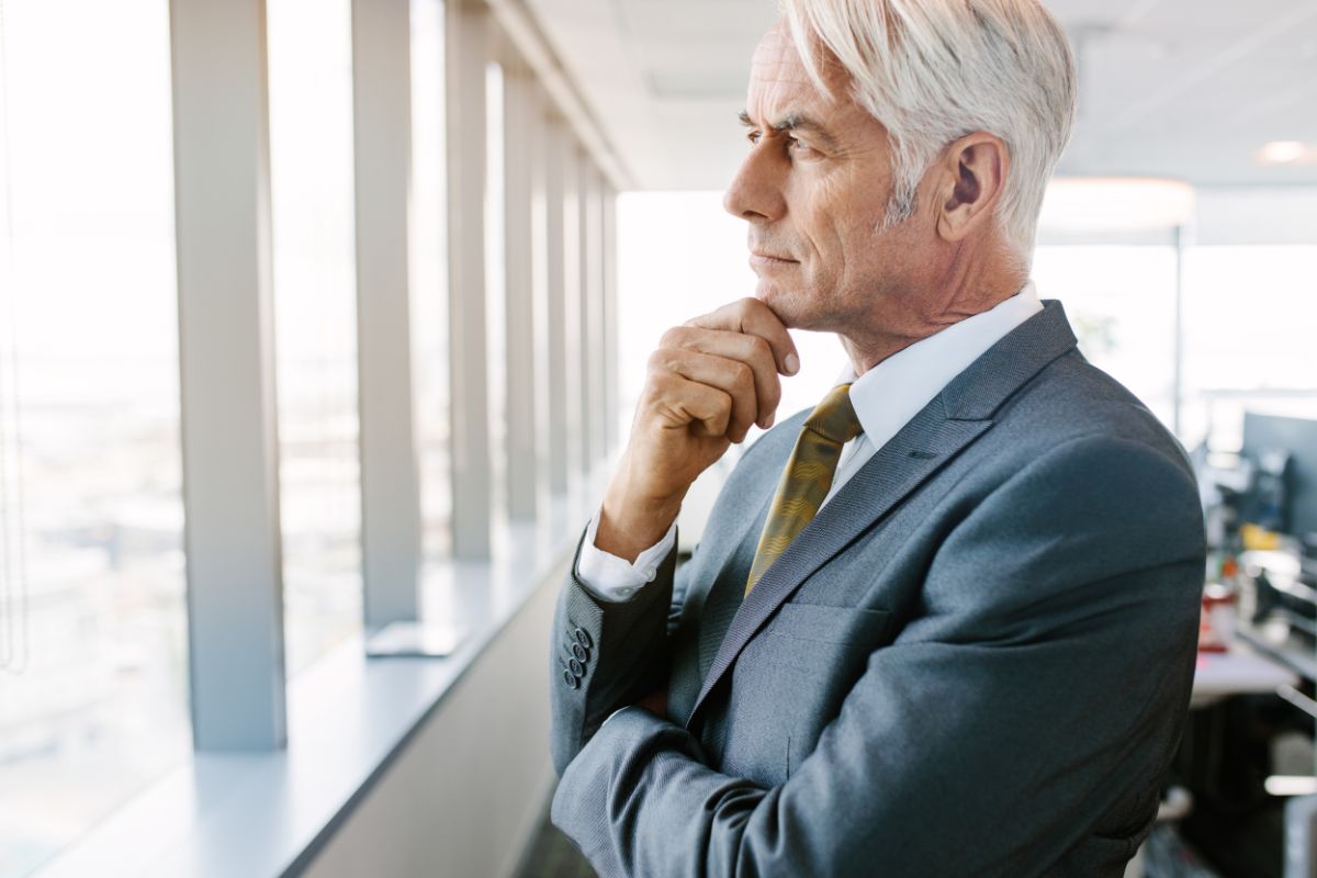 The picture shows a senior man in a suit thinking which refers to Can I truly retire that depends on lifestyle choices that can help you get there.