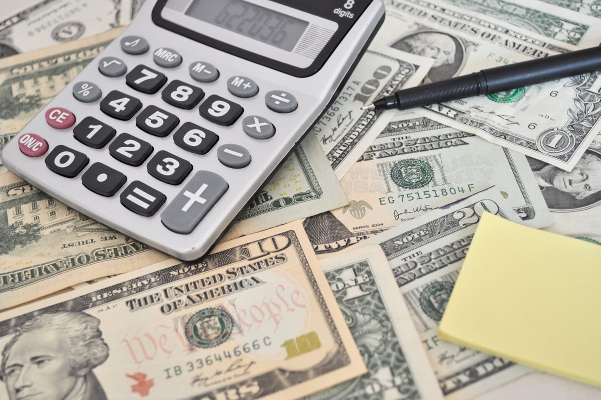 The photo shows a pen, a sticker note, and dollar bills which means time to finance your life and start with smart money moves today.