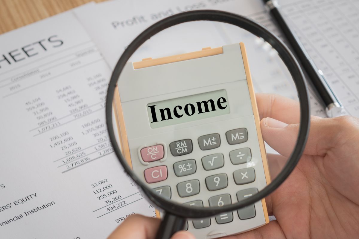 The image shows a man holding a calculator to increase his income.