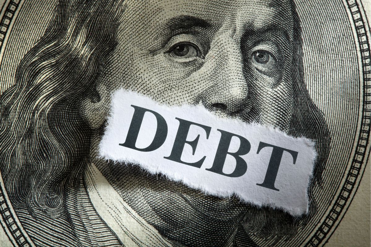The photo tells about a dollar bill icon and a piece of paper with a note indicating that paying off these debts before retirement helps you stay financially free.