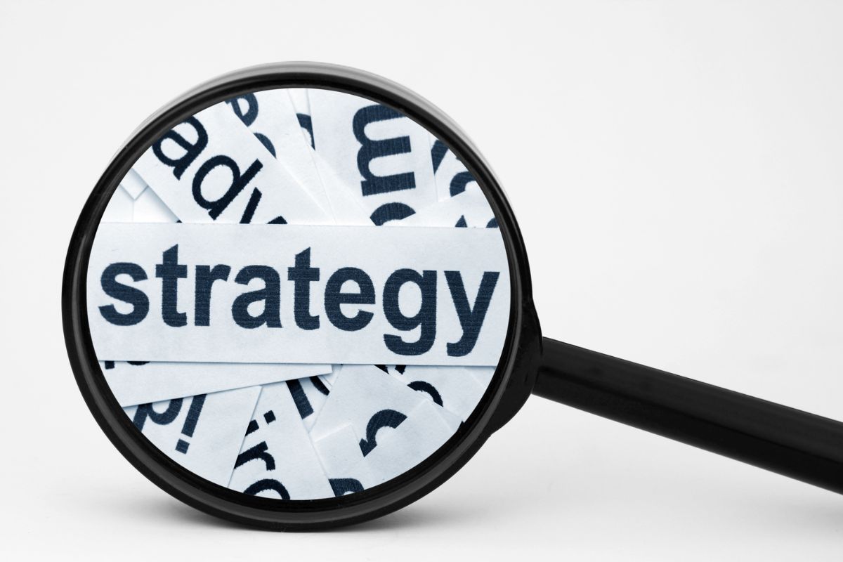 The picture of a magnifying focus on papers with notes that start with these catch-up strategies makes it easier to build a solid retirement plan.