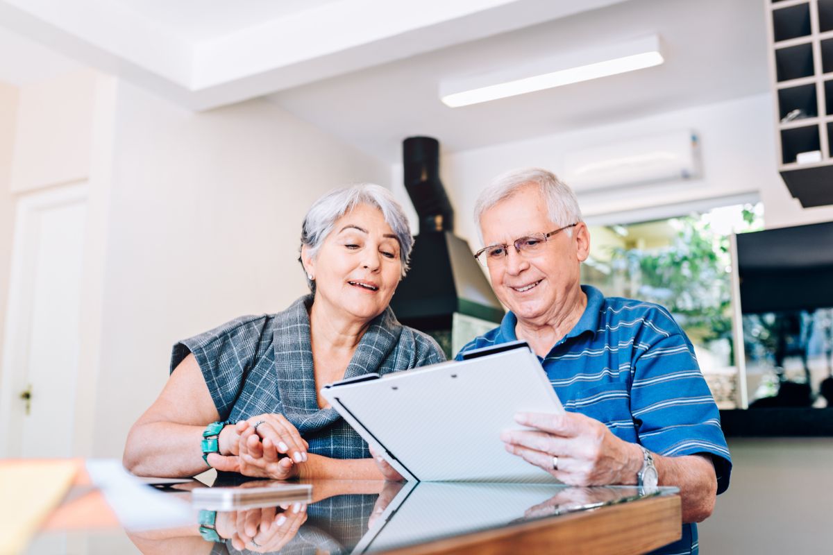 The photo shows two senior couples reviewing the papers indicating that taking care of these issues before death helps avoid fights and confusion.