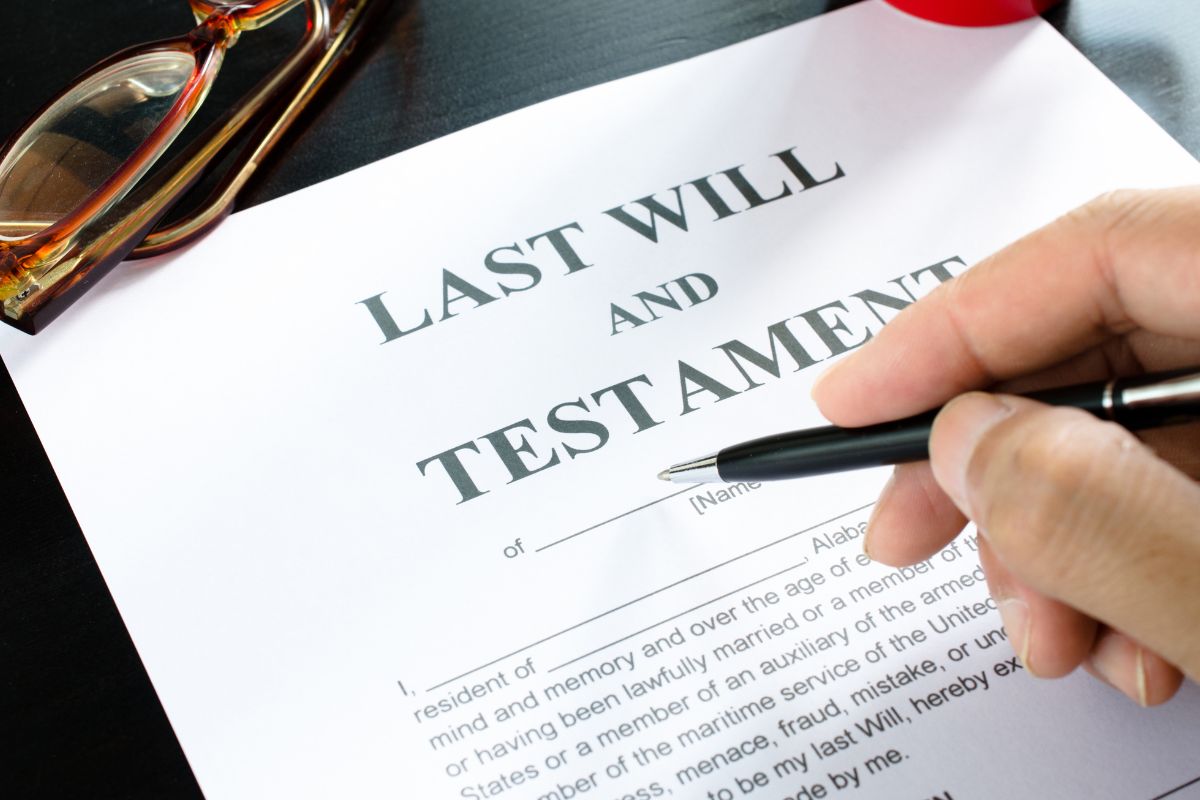 The picture tells about an eyeglass, a piece of paper with notes, and a man's hand holding a pen referring to making sure you don't forget these items in your will to avoid big problems in the future.