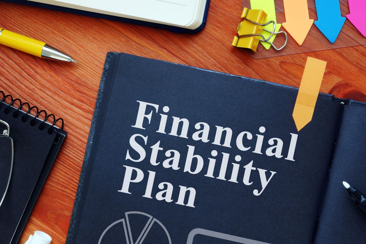 The image shows a black paper with financial stability plan wording.