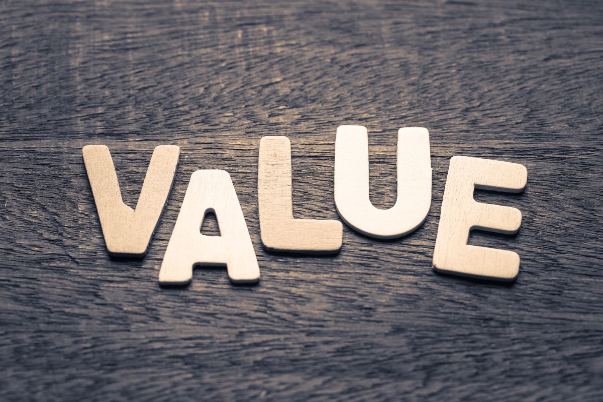 The image shows wooden letters on the table which means focusing on value is a smart way to manage your money.